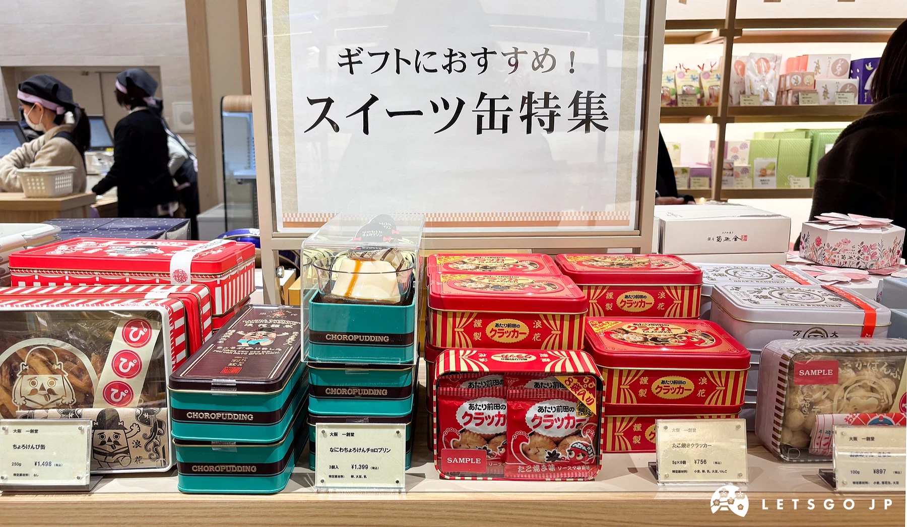 铁盒饼干专区架上放着不同品名的铁盒零食