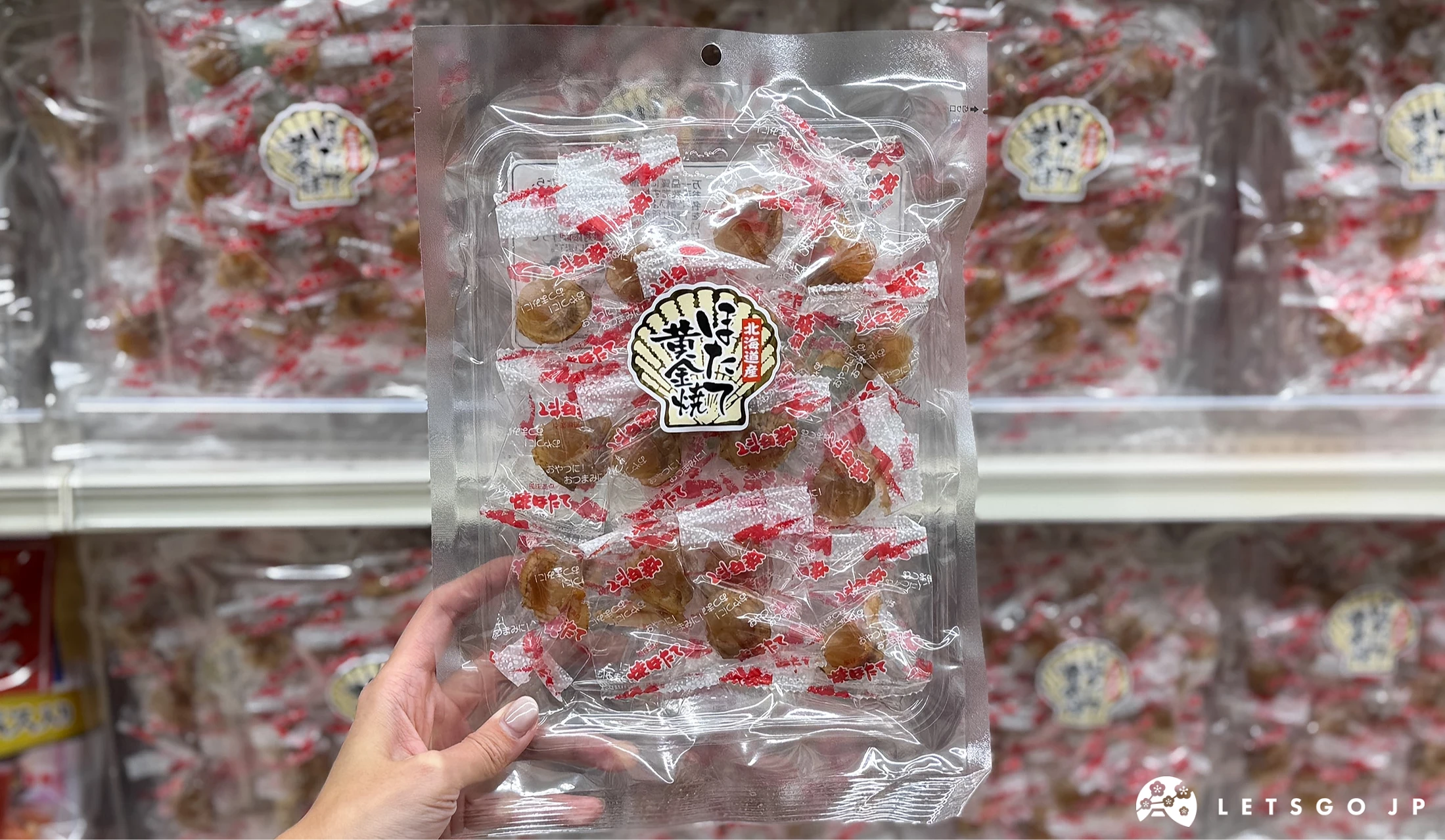 手拿干貝黃金燒的零食在貨架前