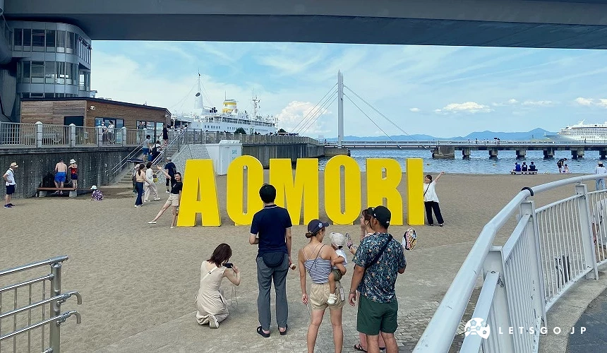 海边沙滩上有黄色「AOMORI」字母装置