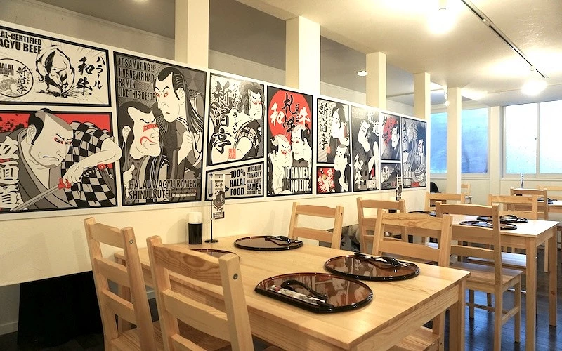 四方形木頭桌上擺上著黑色餐墊