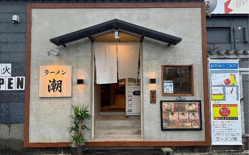 拉麵店外觀，門口掛有暖簾與菜單看板