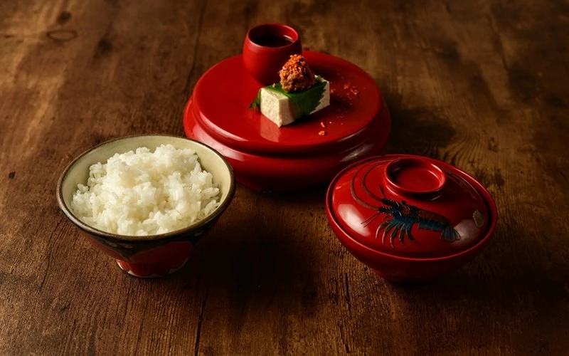 一份紅色餐碗中的料理及一碗白飯