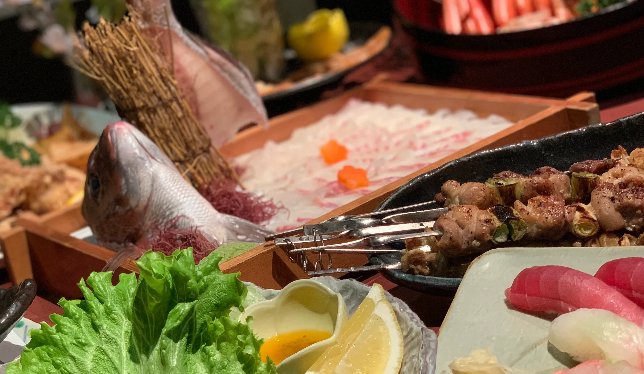 居酒屋 Torihachi 的料理合照,包含新鮮刺身、燒鳥串、握壽司與多道日式下酒菜