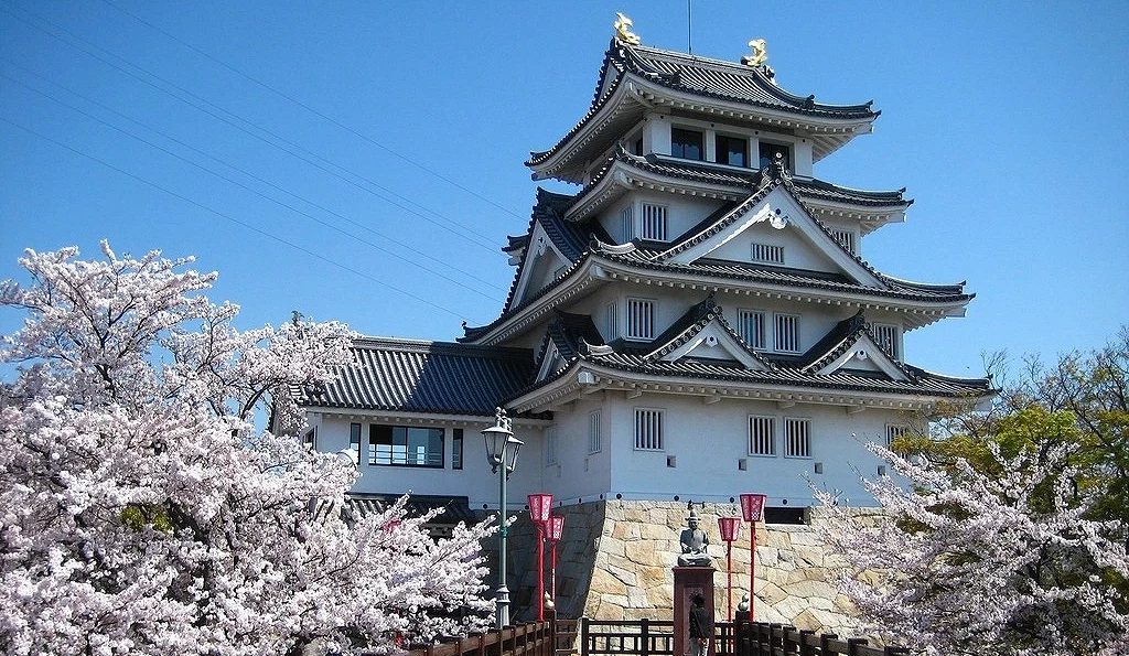 櫻花盛開時的墨俣一夜城天守景色,前景為櫻花與步道,後方可見白色城堡建築