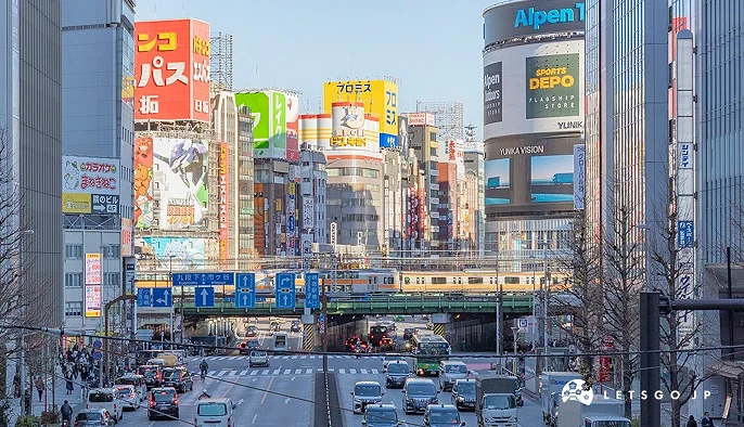 新宿五顏六色的高樓群,大樓之間有黃色電車通過