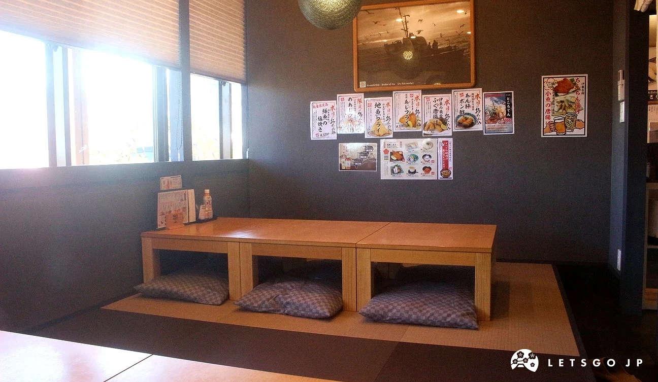 伊豆太郎餐廳內部，設有木質長桌與深藍色坐墊的榻榻米和式用餐區，光線充足且溫馨。