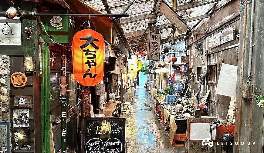 荣町市场附近巷弄景象,悬挂灯笼与招牌的小店林立,呈现冲绳复古怀旧的街道氛围