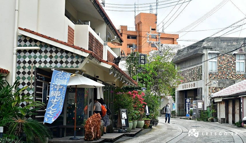 壶屋通街道景象,两侧为陶器店与琉球风格建筑,石板路延伸呈现传统工艺街区氛围