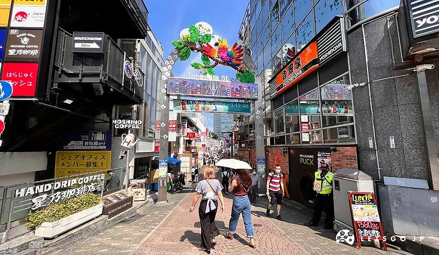 竹下通入口拱門與街道景象,行人走在兩側商店林立的原宿步行街