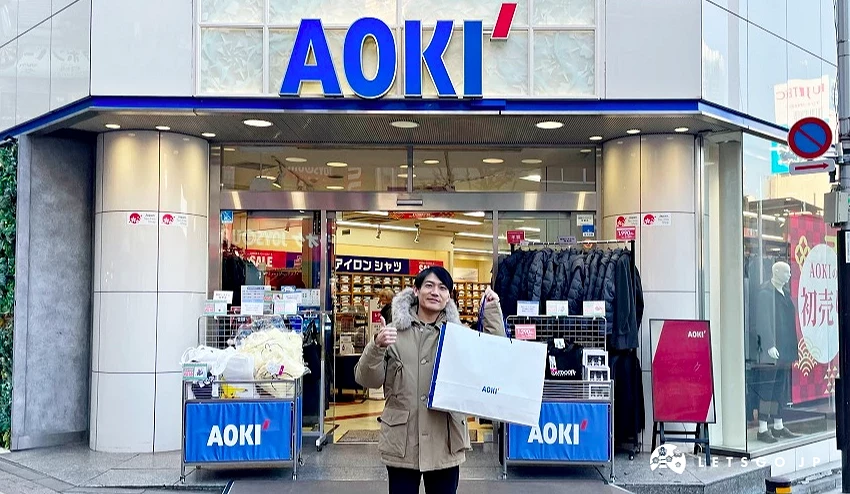 一位男士站在AOKI西裝店的前面