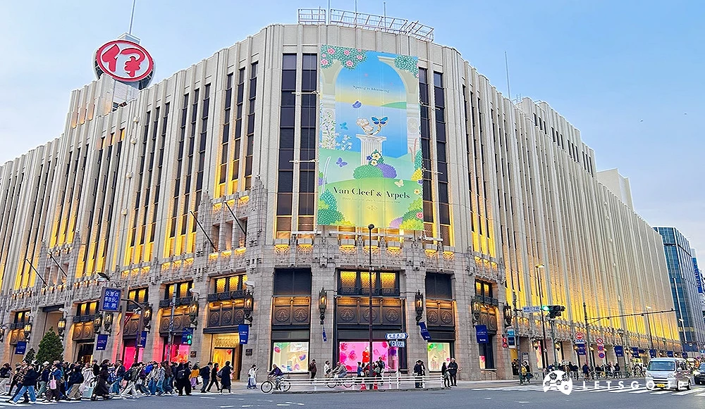 伊势丹百货建筑外观,墙面挂有 Van Cleef & Arpels 大型海报。