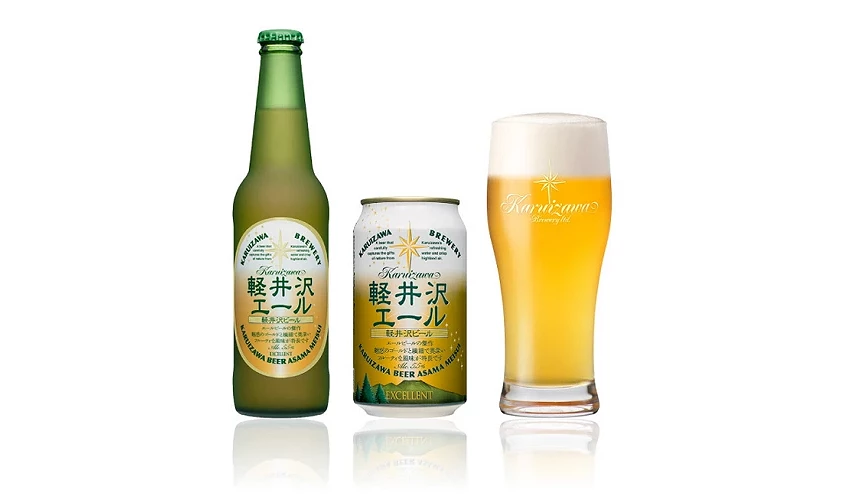 轻井泽艾尔啤酒(軽井沢エール)的商品展示,包含左侧的绿色玻璃瓶装、中间的白底金字易开罐,以及右侧倒满金黄色啤酒与浓密泡沫的专属玻璃杯