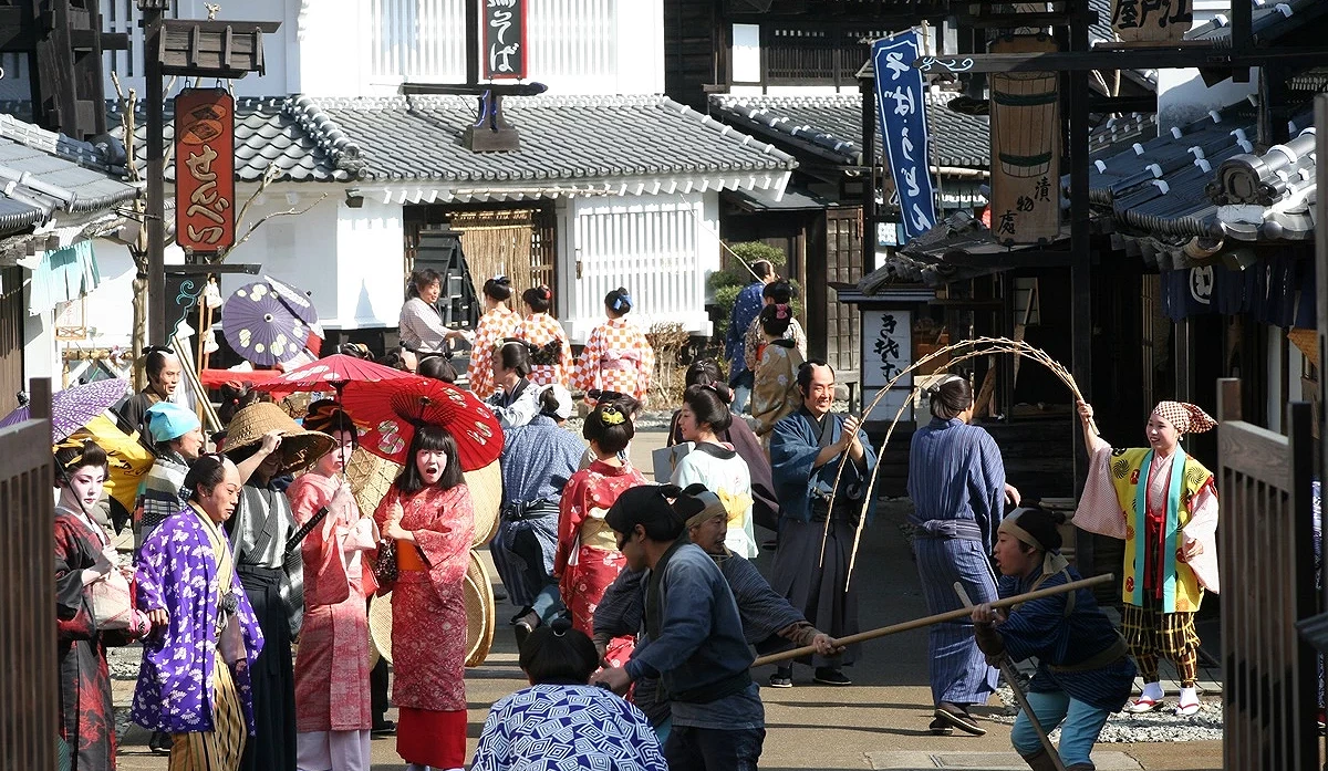 日光江戶村園區實景,街道上有許多穿著和服、武士服與江戶時期裝束的人群,氛圍寫實。