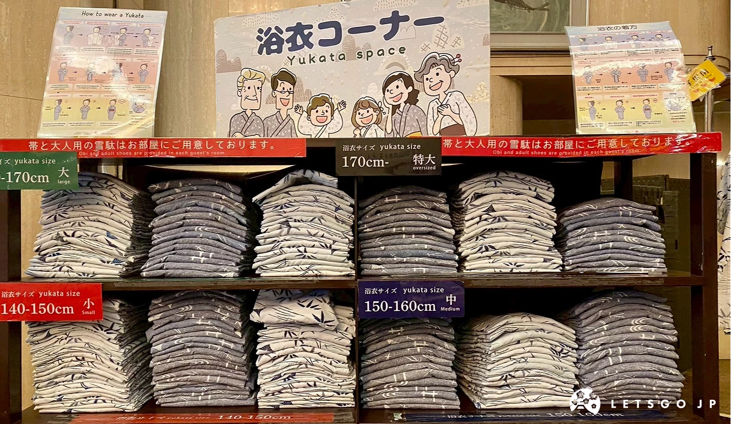 層架上整齊擺放著各種尺寸的日式浴衣,上方有清楚的尺寸標示牌。