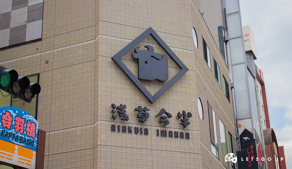 淺草今半建築外牆,掛有牛頭標誌與店名招牌。