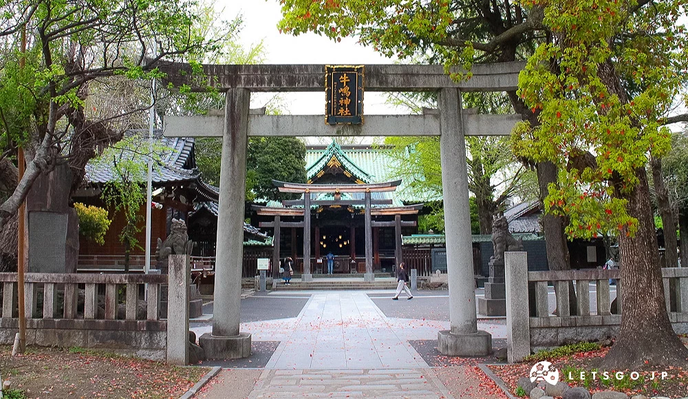 牛嶋神社石造鳥居,後方為神社本殿與周邊林木。