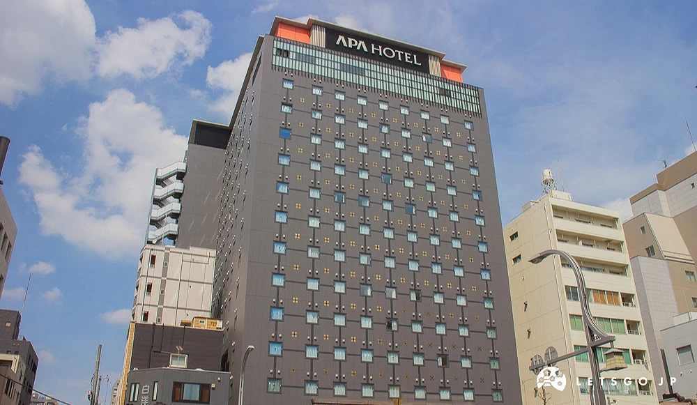 APA Hotel 建築全景,深灰色外牆設有排列整齊的窗戶。