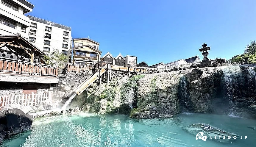 草津温泉汤畑,温泉水流经木制设施并汇入池中的景象