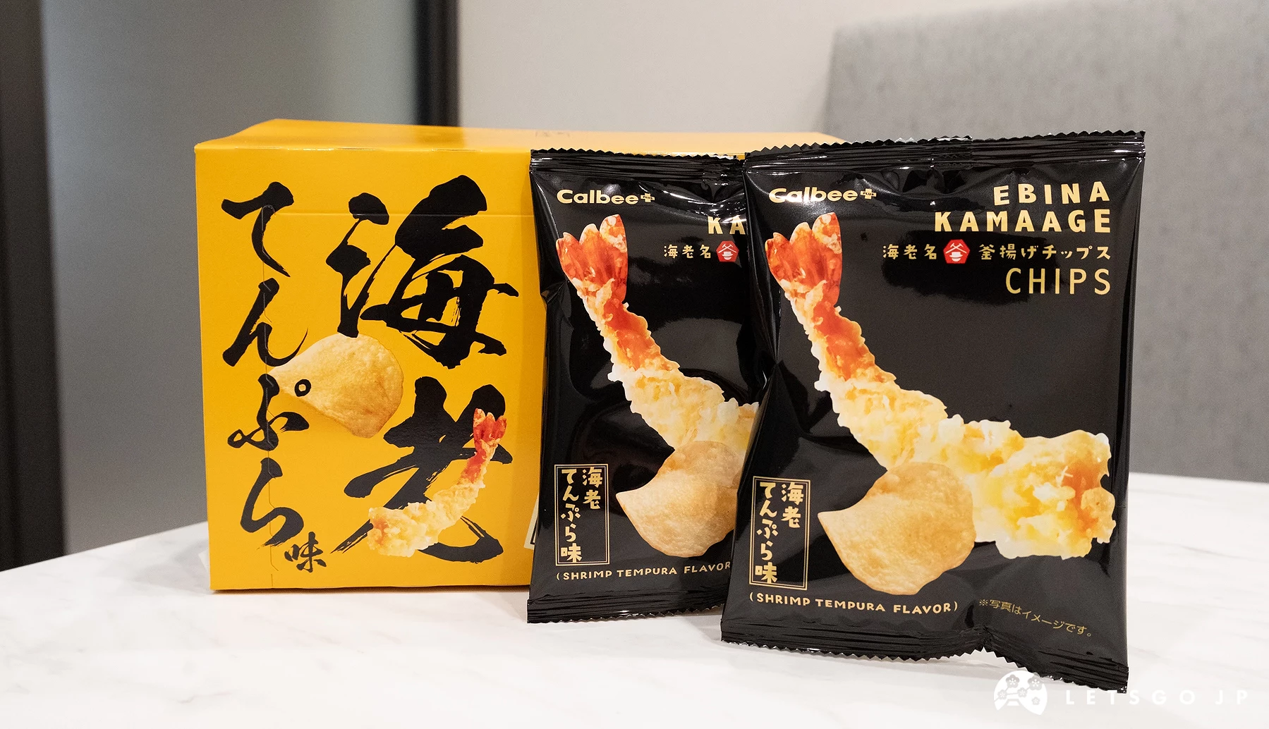 桌上擺放一盒與兩小袋洋芋片