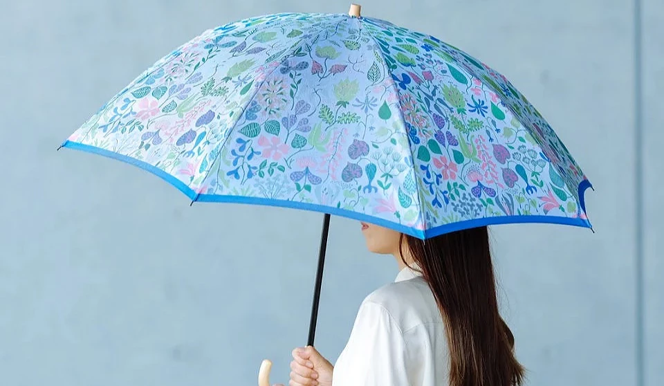 一名女子撐著淺藍色碎花圖案雨傘