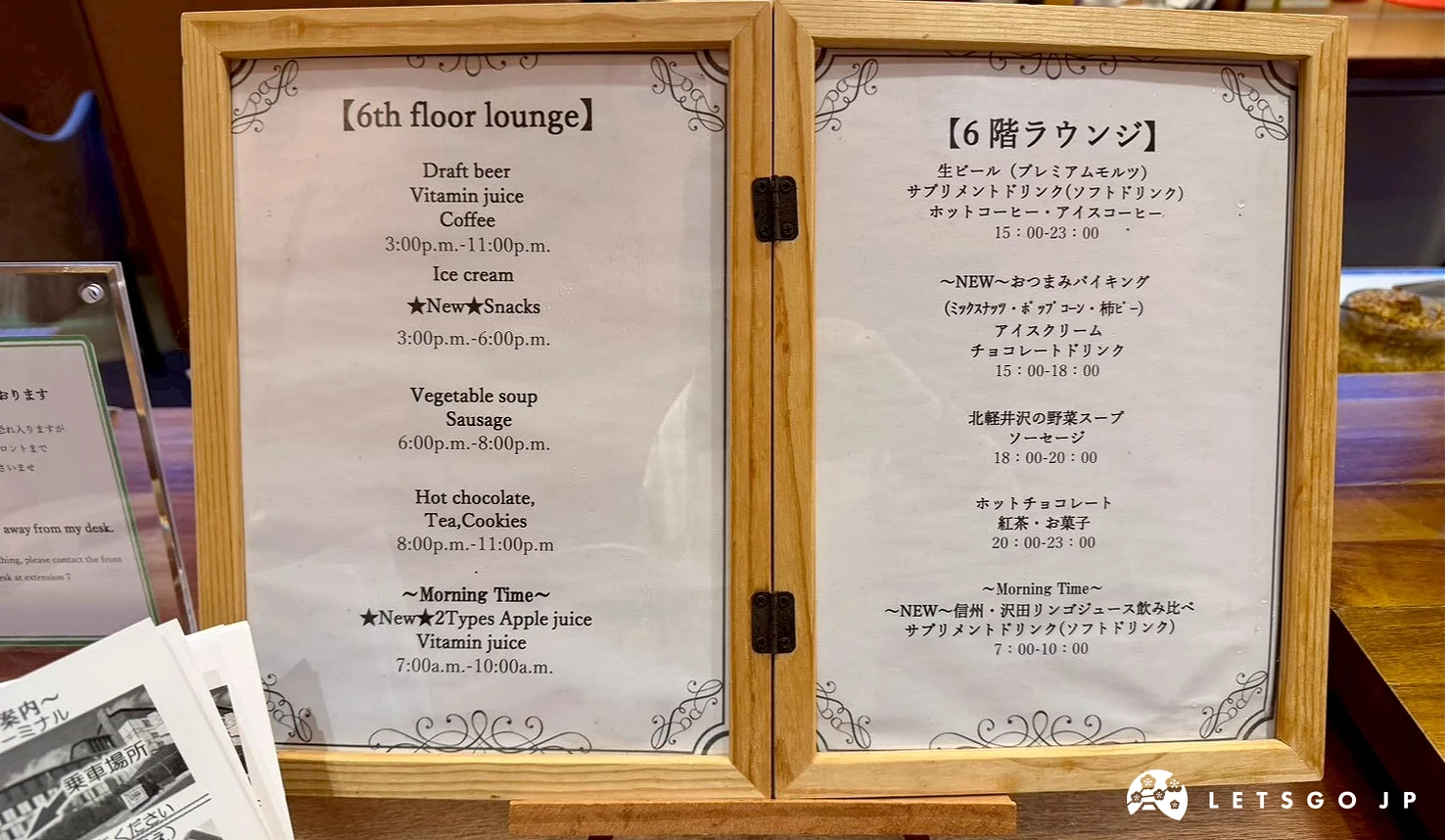 木框告示牌列出 Lounge 的免費飲品與宵夜拉麵供應時間。