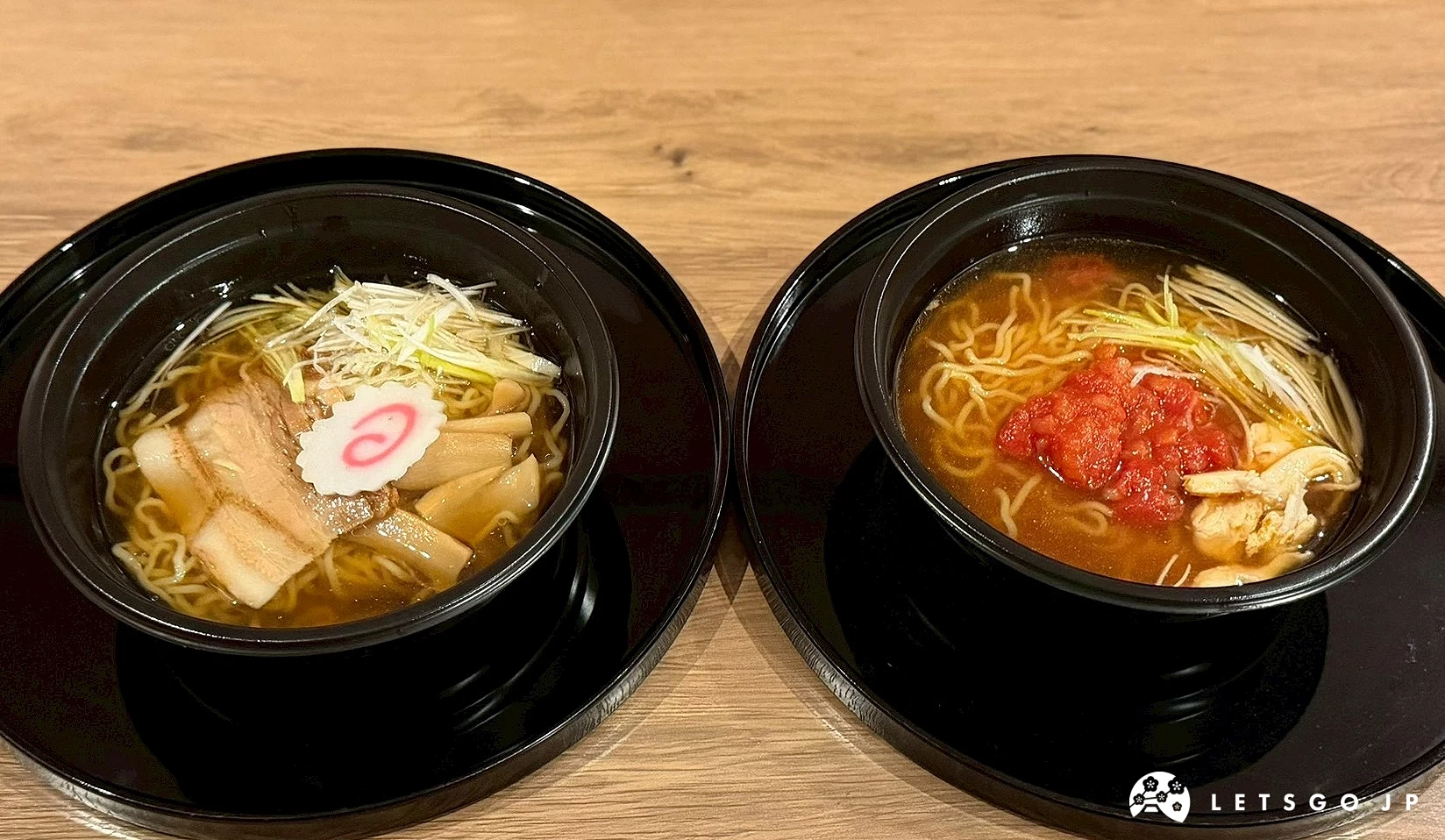 托盤上的兩碗日式醬油拉麵，配有魚板、筍乾與蔥花。