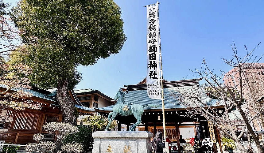 神社手水舍旁竖立着博多总镇守栉田神社的幡旗与马匹石像