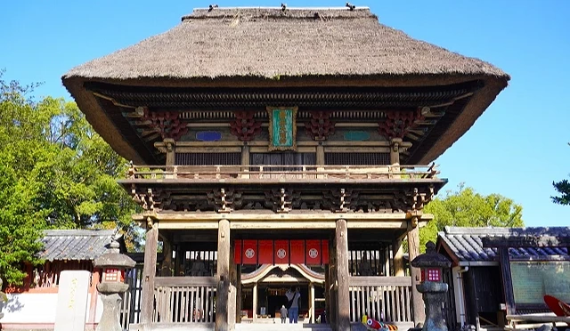 熊本縣人吉市青井阿蘇神社的茅草屋頂樓門，木造門樓前方設有石燈籠與參拜入口