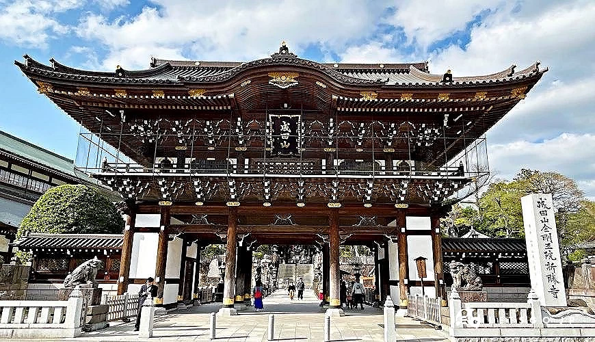 成田山新勝寺山門正面,木造寺院建築在藍天白雲下展現莊嚴氣勢