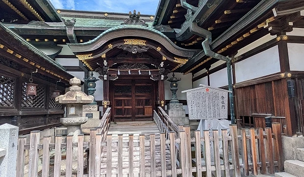 大阪天滿宮登龍門建築，木造結構與曲線屋頂，前方設有參拜階梯與圍欄