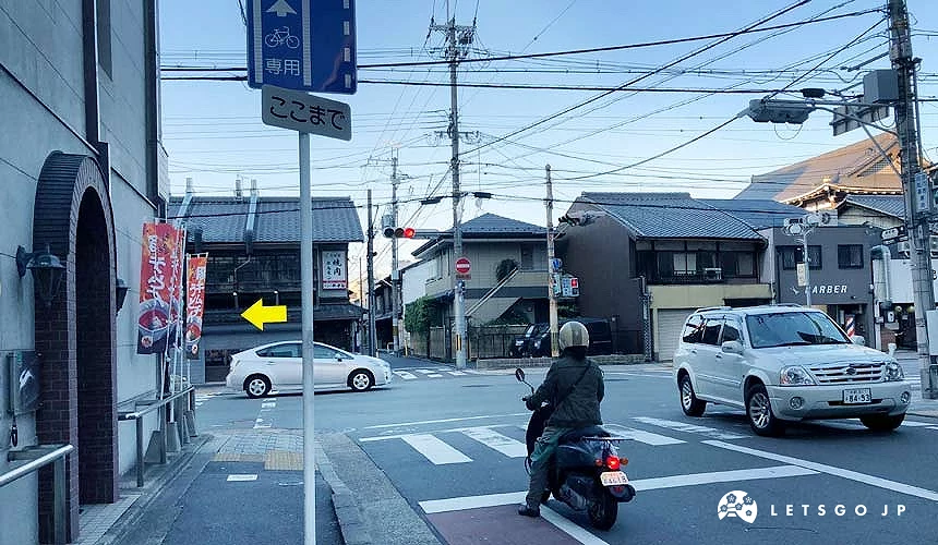 十字路口上有等待紅綠燈的車輛及機車