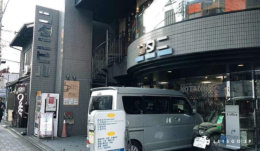 一台車子停在灰色建築前