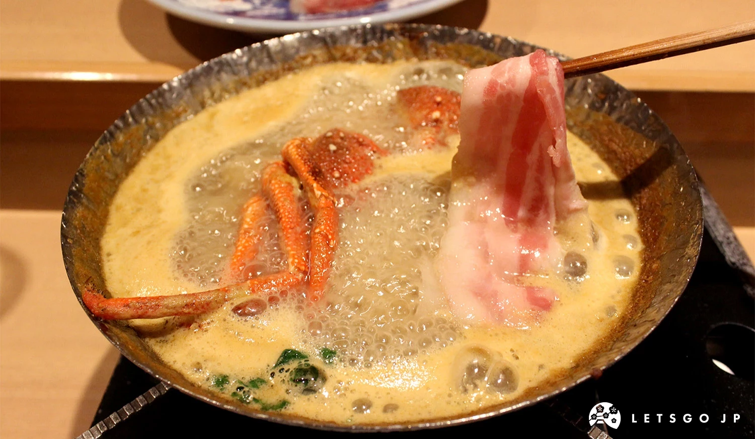 在「豪華海膽火鍋」中清涮肉片