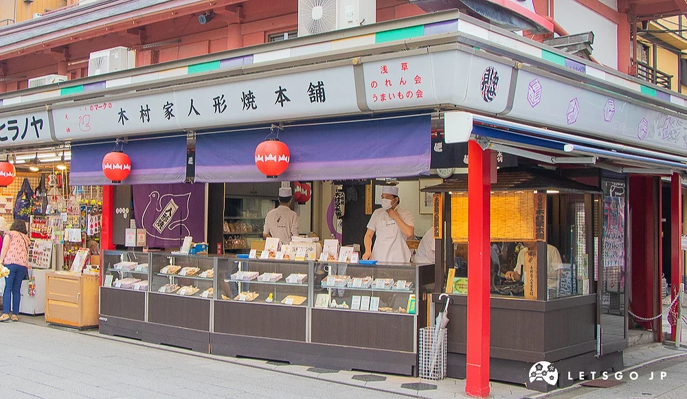 木村家人形燒本舖 木村家人形燒店面,櫥窗陳列多種人形燒產品,師傅在內部作業。