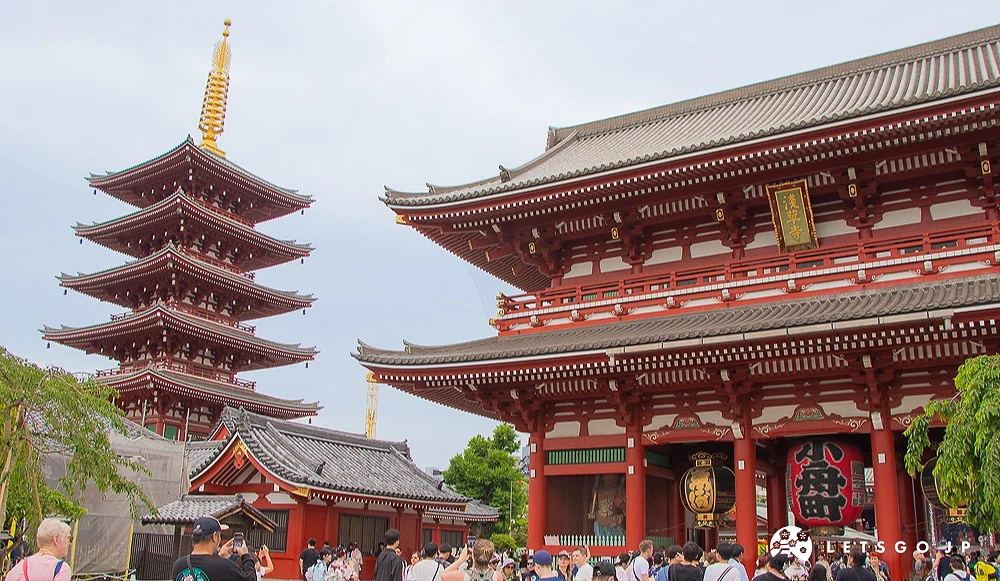 五重塔與寶藏門 淺草寺五重塔與寶藏門並立的景觀,天空微雲,前方有許多遊客正在拍照參觀。
