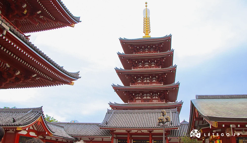 五重塔與寶藏門 淺草寺五重塔與寶藏門並立的景觀,天空微雲,前方有許多遊客正在拍照參觀。