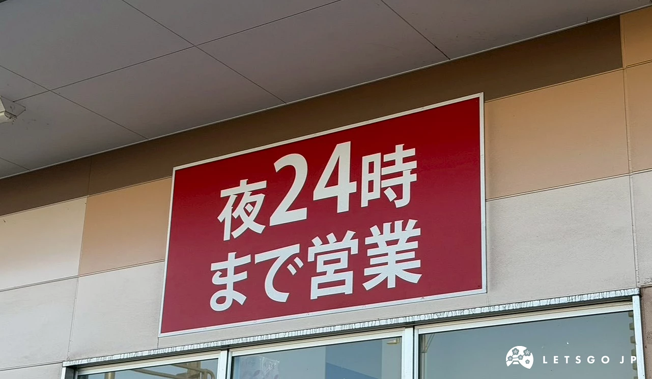 Happy Drug店面玻璃窗上方懸掛的紅色橫式醒目招牌,上面寫著白色的日文「夜24時まで営業」。