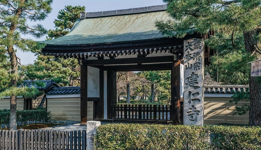 木造的日式屋頂大門，前方設有刻著臨濟宗大本山建仁寺字樣的石柱