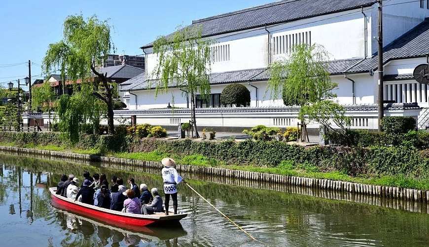 搖船船夫在船上為遊客們解說沿途風景
