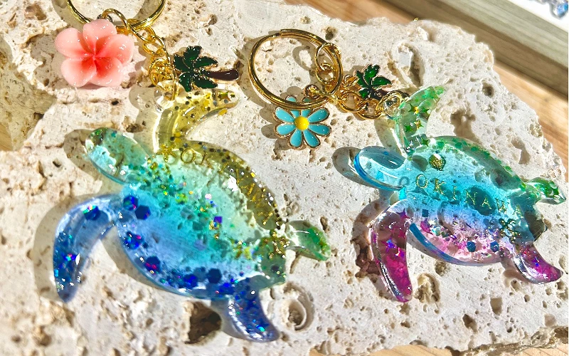 藍綠色海龜造型樹脂吊飾與花朵鑰匙圈擺放展示