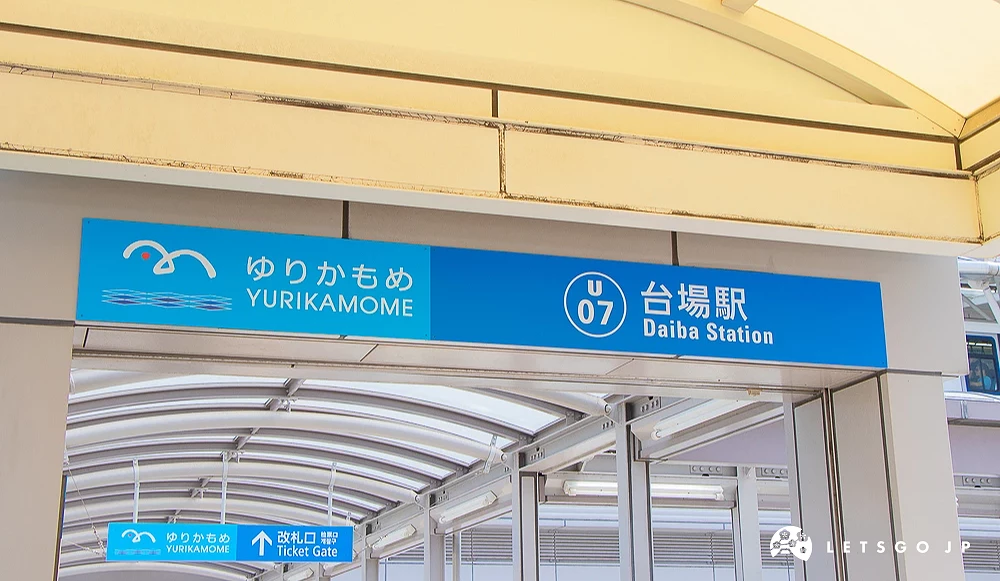 台場站內導覽標牌 百合海鷗號台場站內藍色指示牌,標示站名與改札口方向。