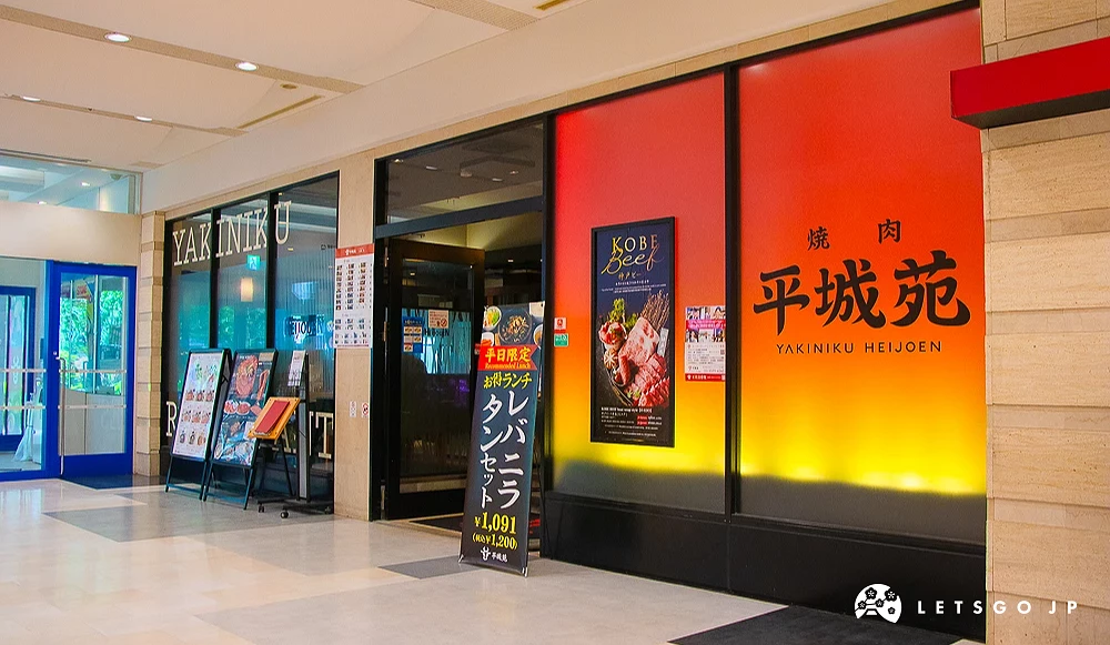 燒肉平城苑店面 平城苑餐廳紅色與黃色漸層外牆,印有黑色品牌文字與神戶牛海報。
