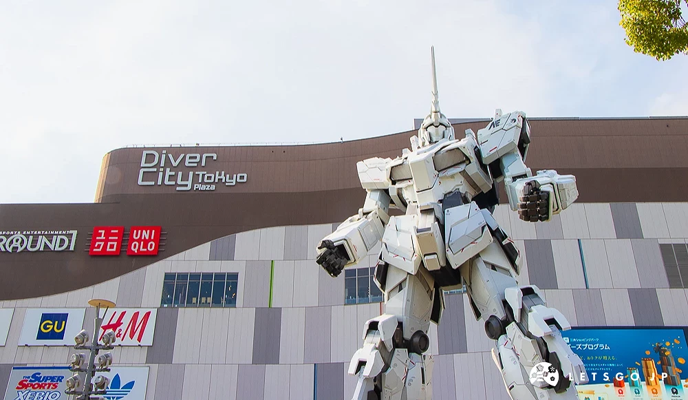 獨角獸鋼彈巨大模型 DiverCity 商場前方立有巨大的白色鋼彈模型,背景可見 UNIQLO 招牌。