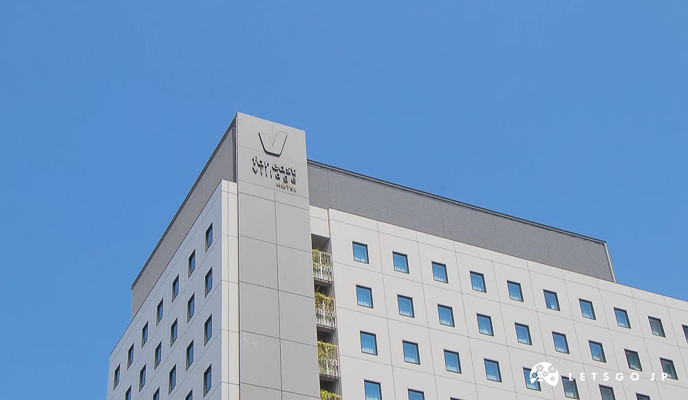far east village 飯店高樓 遠東鄉村飯店大樓頂端,牆面標示著「far east village HOTEL」品牌文字。