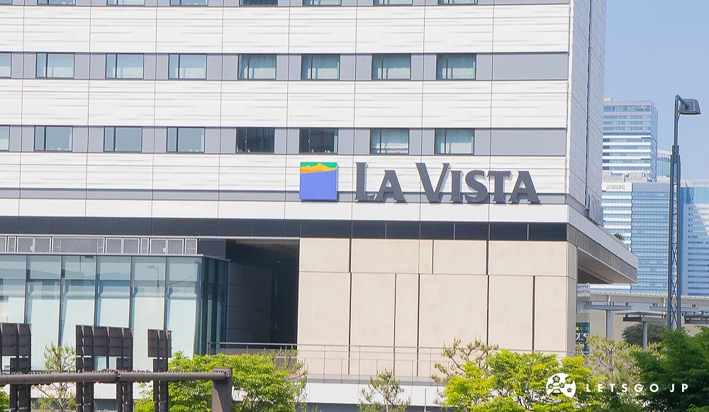 La Vista 飯店大樓 白色外牆建築中央設有藍橘相間標誌,並標示著「La Vista」品牌名稱。