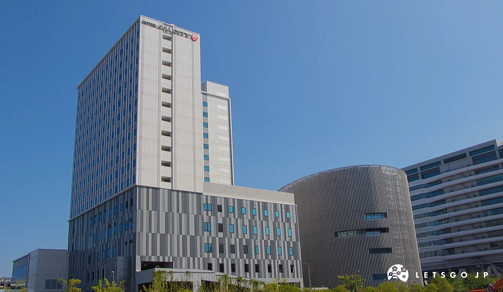 HOTEL JAL CITY 豐洲 日航城市飯店高聳建築,頂端帶有紅色標誌,右側為圓柱形幾何構造大樓。