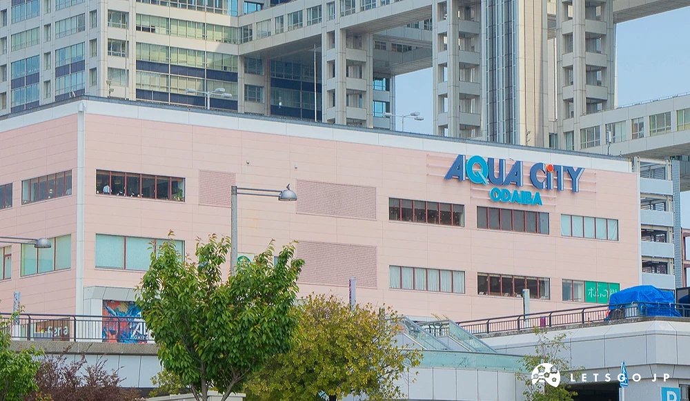 AQUA CITY ODAIBA 外觀 粉色外牆建築上方設有藍色「AQUA CITY ODAIBA」品牌標誌。
