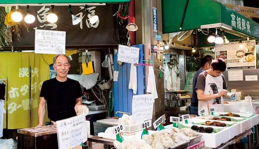 魚福的店員與擺著扇貝等商品的攤位