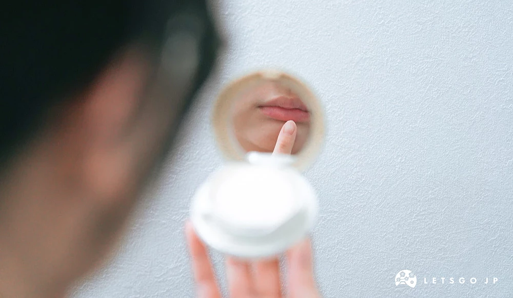 女生拿着化妆镜看着自己的嘴唇