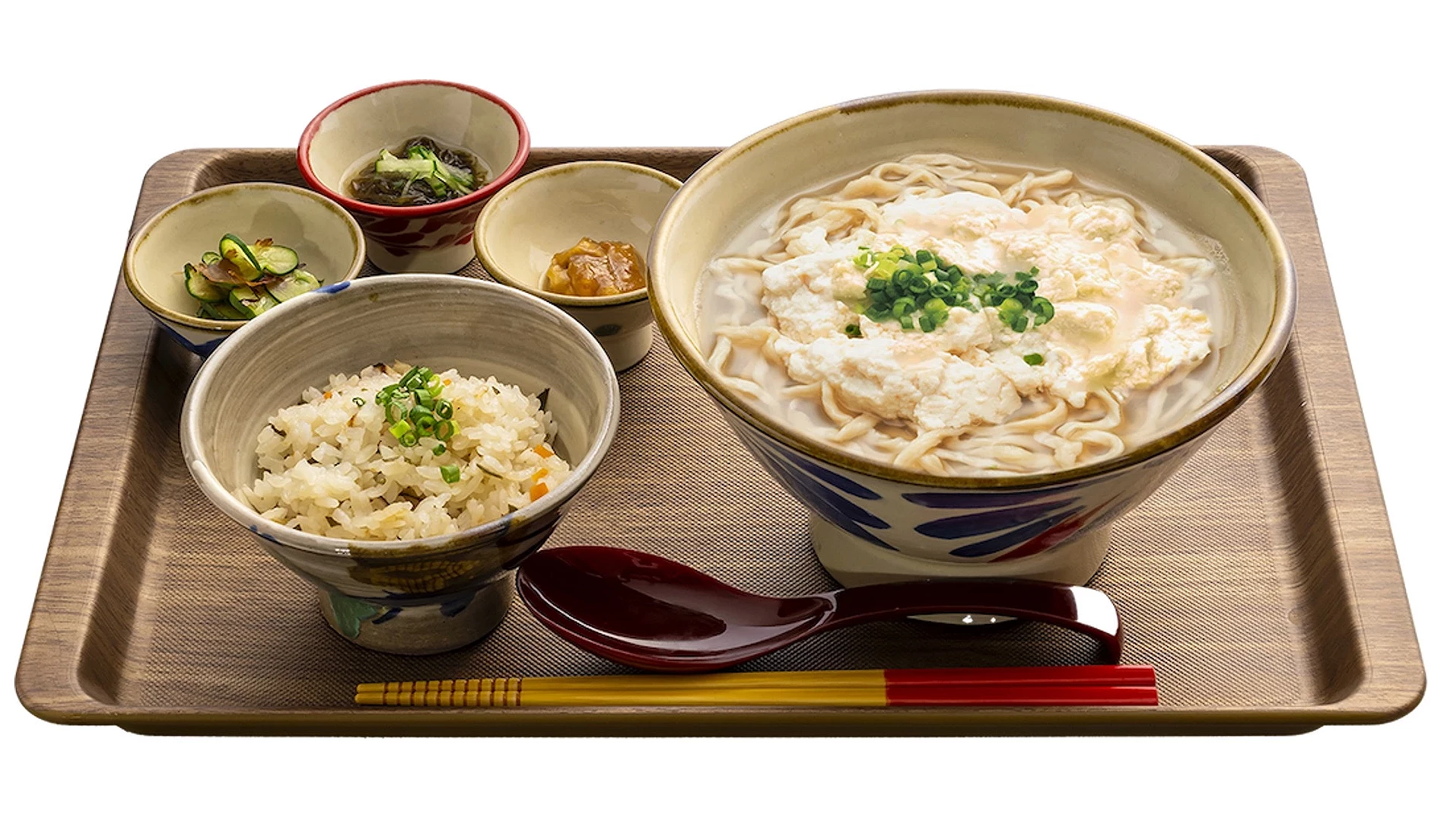 木托盤上擺有豆腐湯麵、炊飯及三碟小菜，附紅色湯匙與筷子的沖繩定食套餐